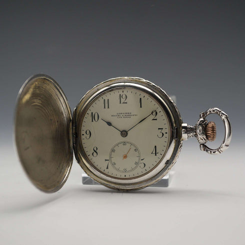 Reloj de bolsillo Longines antiguo de alrededor de 1907, con caja de plata tipo saboneta con relieve grabado, en buen estado de funcionamiento.