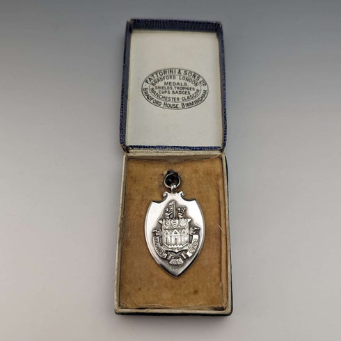 Fob de plata de ley con forma de escudo, vintage británico de 1928, de Fattorini & Sons, en su estuche.