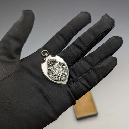 Fob de plata de ley con forma de escudo, vintage británico de 1928, de Fattorini & Sons, en su estuche.