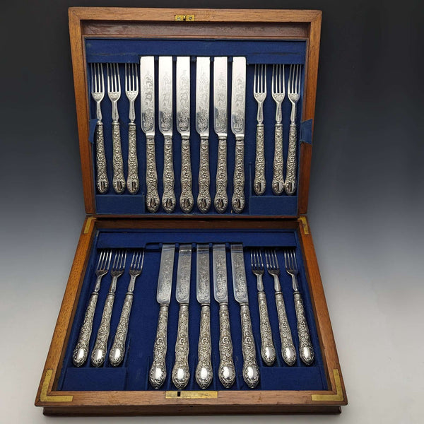 Hacia 1878, juego de cubiertos de plata chapada antiguos de Inglaterra, 11 cuchillos y 12 tenedores, en caja de madera, William Gallimore