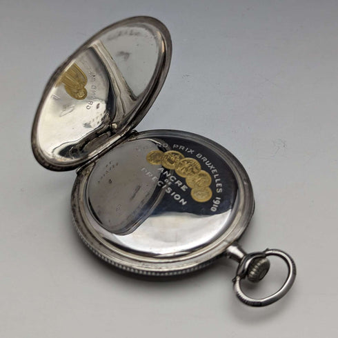 Reloj de bolsillo suizo antiguo, circa 1920, marca Escasany, caja delgada de plata con decoración de niel, en buen estado de funcionamiento.