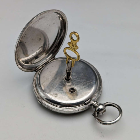 Reloj de bolsillo antiguo Bauer de hacia 1880, esfera decorada, carga por llave, caja de plata, diámetro 44 mm, en funcionamiento, con defectos.