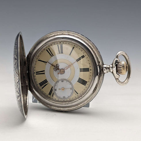 Reloj de bolsillo antiguo de fabricación suiza, sin marca, caja de plata con fino trabajo en nielo, tipo saboneta, en buen estado de funcionamiento.