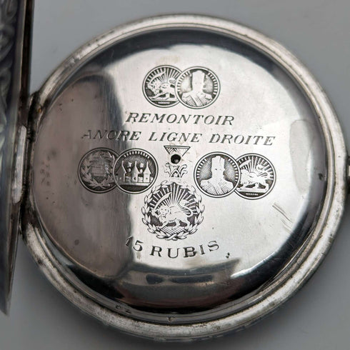 Reloj de bolsillo antiguo de fabricación suiza, sin marca, caja de plata con fino trabajo en nielo, tipo saboneta, en buen estado de funcionamiento.
