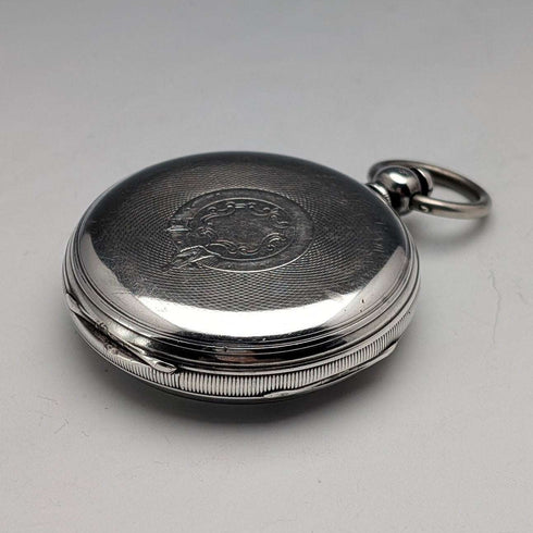 Reloj de bolsillo inglés antiguo de 1864, John Bennett, de cuerda con llave, caja de plata, esfera abierta, en buen estado de funcionamiento.