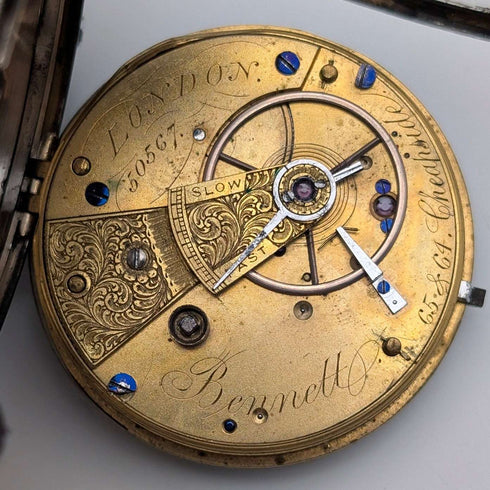 Reloj de bolsillo inglés antiguo de 1864, John Bennett, de cuerda con llave, caja de plata, esfera abierta, en buen estado de funcionamiento.