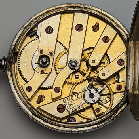 Reloj de bolsillo antiguo para dama, de fabricación suiza, en buen estado de funcionamiento, con caja de plata con grabado floral y cuerda por llave.