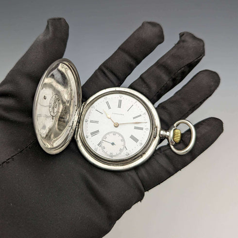 Reloj de bolsillo Longines antiguo, circa 1907, caja de plata tipo saboneta con grabados florales, en buen estado de funcionamiento.